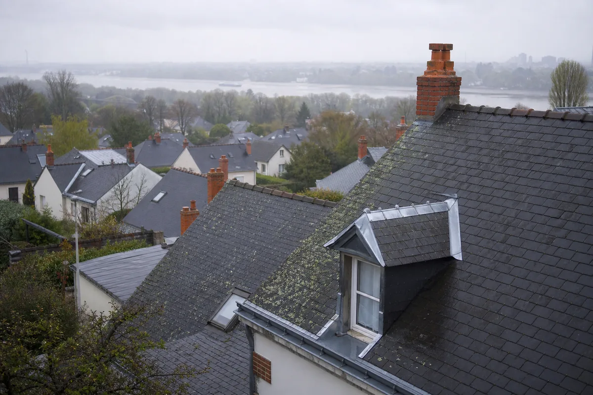 Toits d’ardoise d’un quartier nantais sous un ciel gris perle après la pluie