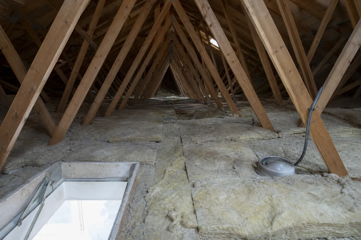Combles perdus d’un pavillon nantais avec charpente en fermettes et ancien isolant tassé